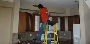 Water Damage Professional Working On A Ceiling Repair Job